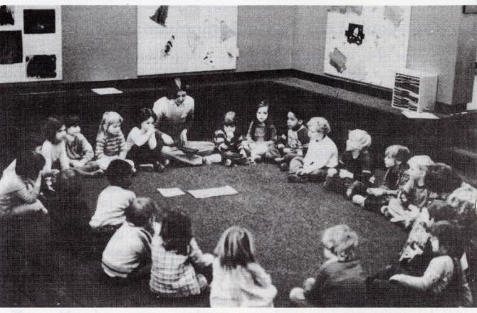 group of children together at a table discussing