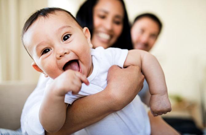 smiling baby being held by mother