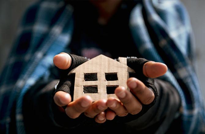 hands holding cardboard house