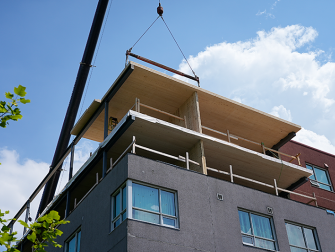 Mass timber panel and roof section lifts for expansion.