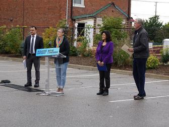 4 people standing outside of the Cornerstone Suite for a public announcement