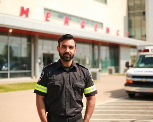 Paramedic standing in front of an Hospital emergency entrance.