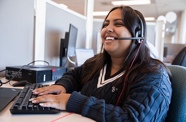woman wearing a headset working at her desk
